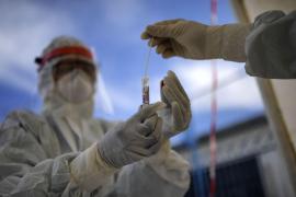 Un pacient pune proba de test Covid in eprubeta oferita de un asistent medical