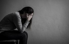 Femeie cu faţa în palpe, privind spre podea