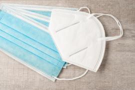 Femeie care își pune o masca FFP2 pe față