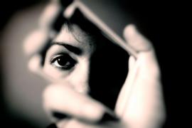 O femeie se privește într-o oglindă