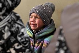 O fetiţă speriată aşteaptă să fie evacuată