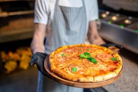 bucătar care pregătește o pizza