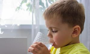 Un băieţel bea un bahar cu apă rece