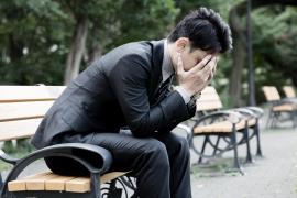 bărbat care plânge pe o bancă