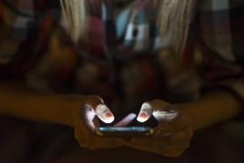 tânără care stă pe telefon noaptea