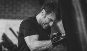 Transpirat, cu muşchii încordaţi, Emmanuel Macron loveşte un sac de box