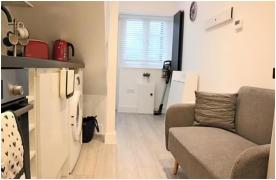 Cu cât se închiriază un garaj transformat în garsonieră, în UK. Are canapeaua faţă în faţă cu chiuveta din bucătărie şi patul în pod