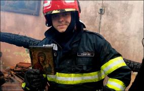 Un pompier ţine în mână icoana salvată din incendiu