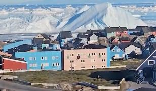 Momentul spectaculos în care un iceberg gigantic se răstoarnă lângă o insulă din Groenlanda