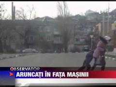 Rusia: O mama cu un copil luati de vant in fata unei masini