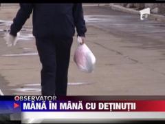 Gardian mana in mana cu detinutii