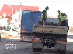 Metoda inedita de a asfalta strazile pentru doi muncitori din Baia Mare! Au aruncat bitum peste gropi, direct din bena unui camion