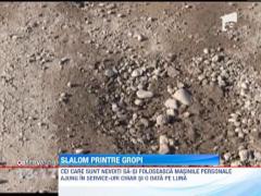 Aproape izolati in case din cauza gropilor din drum