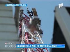 Un bărbat s-a urcat pe un stâlp de telecomunicații, supărat că nu primește ce vrea de la autorități