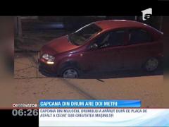Mașină blocată deasupra unei gropi de aprope doi metri adâncime!
