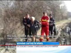 Bătrână captivă în nămol