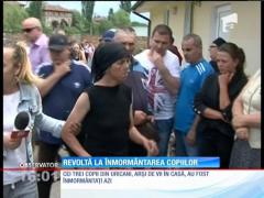 Revoltă la înmormântarea celor trei copii arşi după ce mama i-a încuiat în casă