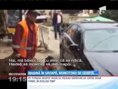 Mașină suspendată după ce a intrat într-o groapă nesemnalizată, muncitorii se ceartă!