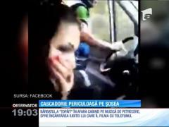 Cascadorie periculoasă. Dansează cu o mână pe volan, în afara camionului care rulează cu viteză pe şosea!