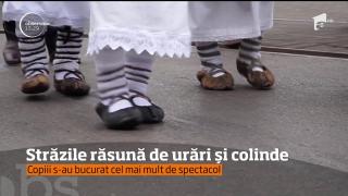 Străzile răsună de urări şi colinde: în straie populare sau mascaţi, colindătorii fac spectacol
