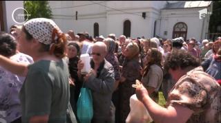 În faţa bisericii, zeci de enoriaşi au uitat de Dumnezeu şi de credinţă şi au pornit la luptă pentru pomană!