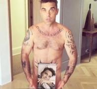 Robbie Williams şi-a surprins din nou fanii după ce, de Crăciun, s-a lăsat forografiat gol, sub vâsc!
