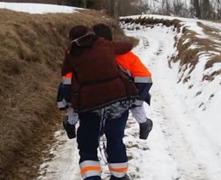 Bătrână cărată în spate până la ambulanță, în Munţii Apuseni. Zeci de localităţi au rămas pierdute în zăpadă