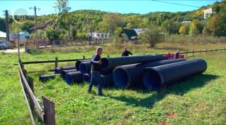 Situaţie inedită într-o comună din Argeş. Electricianul primăriei taie iarba lângă şcoală, iar viceprimarul reface podeţele în faţa curţilor