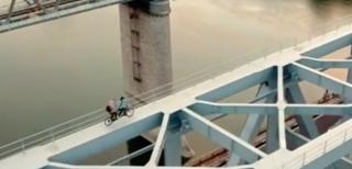 Acrobatul Flavius, plimbare inedită pe două roţi, alături de iubită. Nu în parc, ci pe structura de fier a podului de la Cernavodă