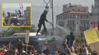 Un polițist care a dat cu spray lacrimogen în protestatari a fost aruncat de pe mașină, în Algeria (Video)
