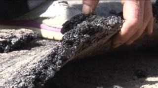 Asfalt abia turnat, smuls cu mâna de pe drum, în Vatra Dornei