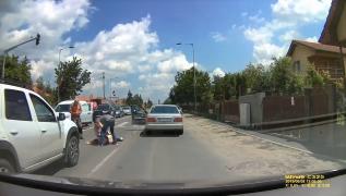 O tânără care trece în fugă strada loveşte cu capul o maşină şi cade inconştientă pe asfalt (Video)