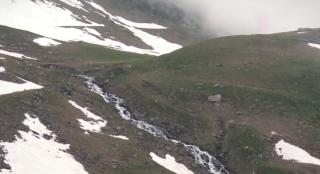 Turiştii se aventurează pe Transfăgărăşan, deşi zăpada este de cinci metri (Video)