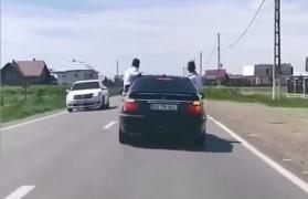 Trei maşini merg în zig-zag pe o şosea din Suceava, cu doi tineri ieşiţi pe geam (Video)