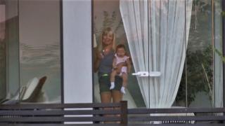 Primele imagini cu Elena Udrea, după întoarcerea în România. Ea a ieşit la fereastră, cu copilul în braţe (Video)