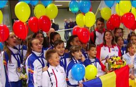 Cu flori, baloane şi cu galerie, aşa au fost întâmpinaţi la aeroport, o parte dintre micii campioni ai României la karate