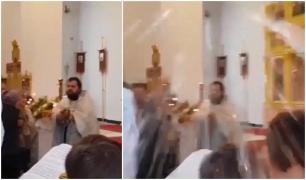 Un preot binecuvântează enoriaşii cu furtunul, în biserică (Video)