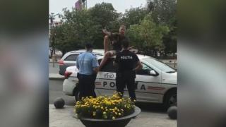 Un bărbat s-a urcat pe mașina de poliție, la Unirii, în semn de protest: "Am sunat la 112 și n-au vrut să vină!" (Video)