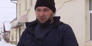 Bărbat în scaun cu rotile, surprins deszăpezind un trotuar din judeţul Braşov. Deşi e greu, Ioan spune că s-a obişnuit