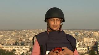 O jurnalistă aflată pe acoperișul unui bloc din Gaza în timpul unui LIVE a surprins cum o clădire vecină este bombardată