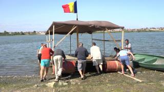 Şase prieteni s-au aventurat pe Dunăre cu o plută din 16 butoaie, scânduri şi lemn: "Mergem spre cetate, Calafat, Bechet; e ceva inedit"