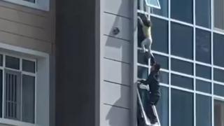 O fetiţă de trei ani care atârna de la fereastră, salvată în ultimul moment de un bărbat din Kazahstan