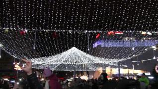 Într-un oraş mare din România deja e Crăciunul. Oamenii se plimbă printre luminiţele de Sărbatori îmbrăcaţi de vară