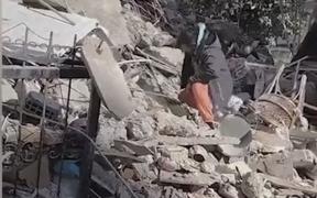 Disperare: Un tată surprins în timp ce bate cu o piatră în dârâmâturi sperând că va primi un semn de viață de sub ruine