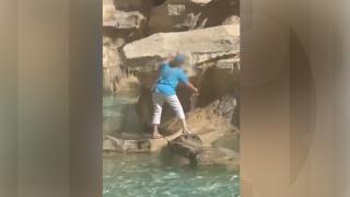 Turistă, surprinsă în timp ce se urcă pe celebra Fontana di Trevi din Roma. Femeia voia doar să îşi umple o sticlă cu apă din fântână