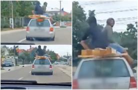 Inconştienţă fără limite: Doi bărbaţi, filmaţi pe plafonul unei maşini aflate în mers, în Suceava. Se sprijineau de nişte lemne