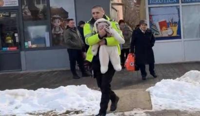 Momentul în care un bebeluș este scos în braţe de un poliţist dintr-un bloc cuprins de flăcări, în Iaşi
