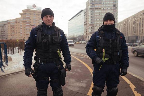 EMOŢIONANT! Urmând exemplul unei fetiţe, jandarmii cumpără flori şi le OFERĂ manifestanţilor de la protestul din Piaţa Victoriei (VIDEO)