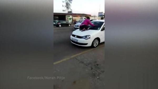 Nu vrea să renunţe! O femeie s-a urcat pe capota maşinii condusă de soţul ei, pentru a-l împiedica să plece cu amanta VIDEO