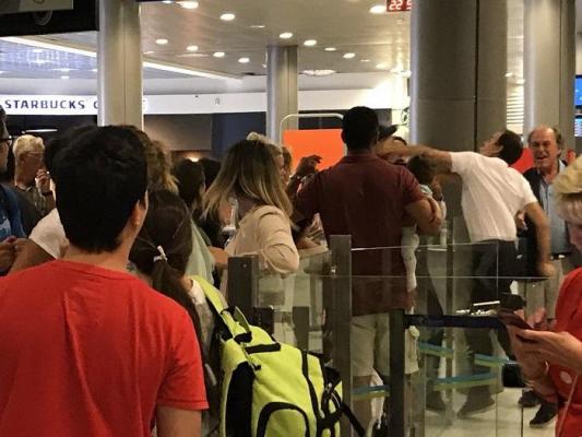 Imagini ŞOCANTE! Un angajat al aeroportului POCNEŞTE un bărbat CU COPIL în braţe, sub privirile ÎMPIETRITE ale celorlalţi pasageri!